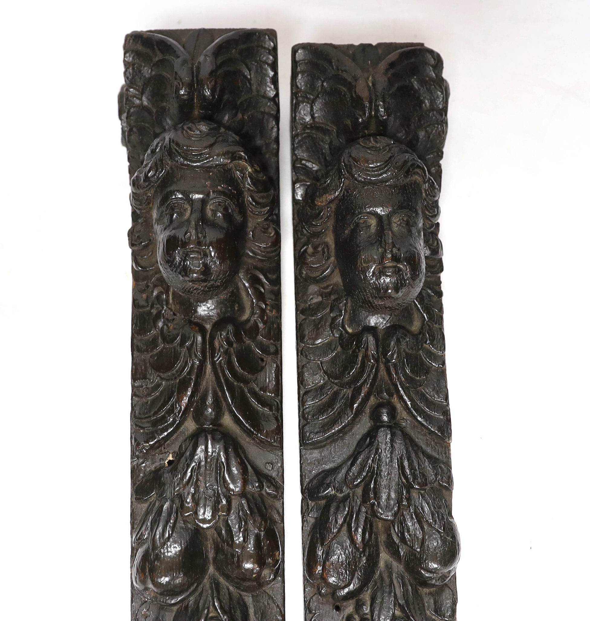 A pair of 17th century carved oak jambs, carved with putti decoration, 39cm